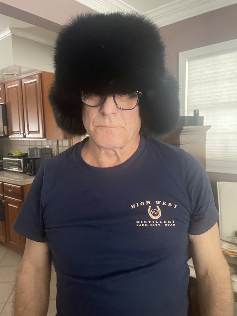 man wearing trapper hat with black fox fur and leather