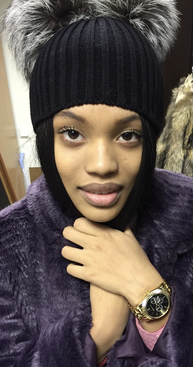 woman wearing black beanie with two silver fox fur pompoms in Kylie Jenner style