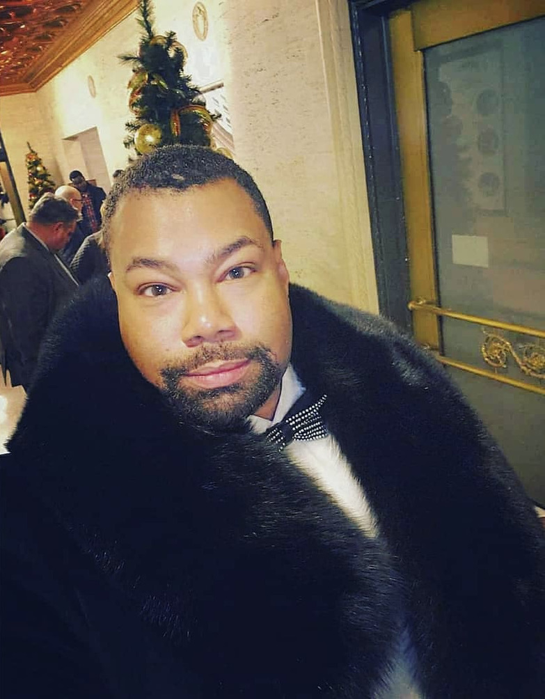 man wearing round black fox fur pelerine wrap
