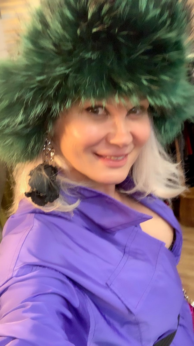 woman wearing emerald green raccoon fur hat