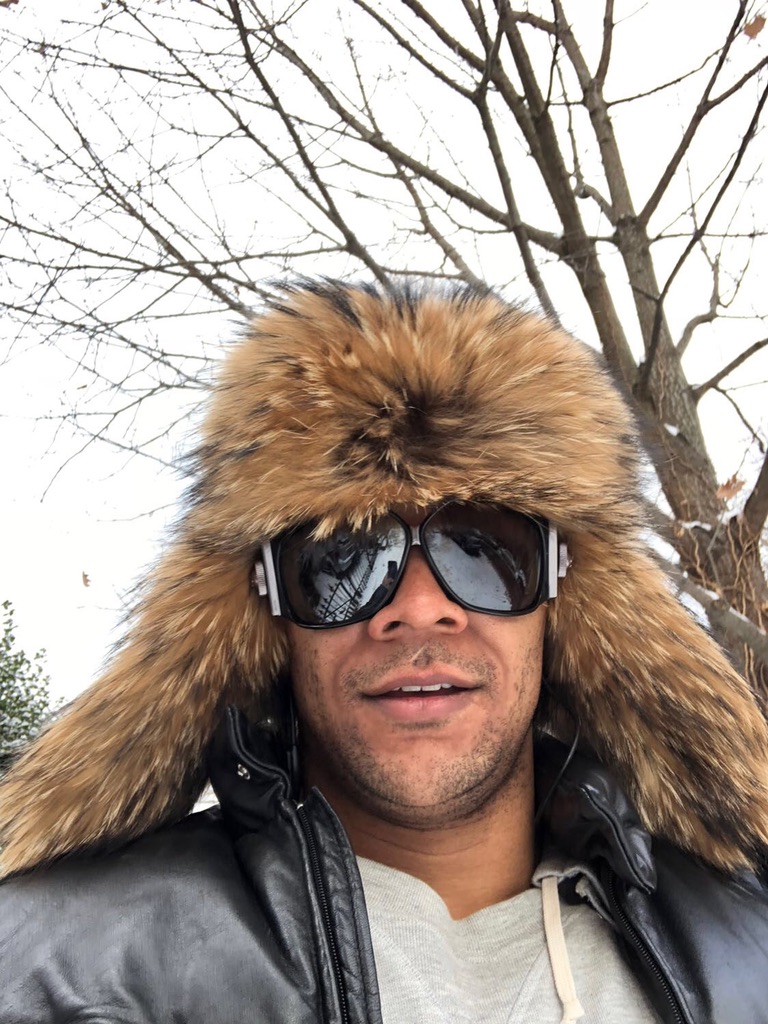 man wearing raccoon fur trapper hat