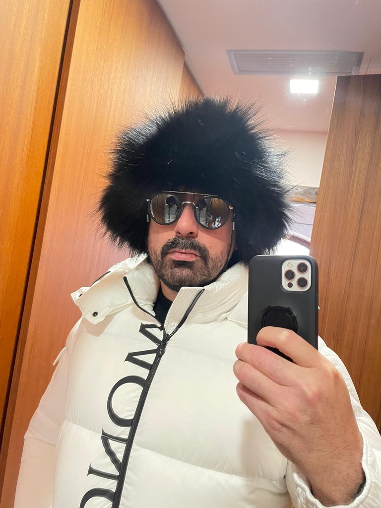 man wearing black raccoon fur trapper hat