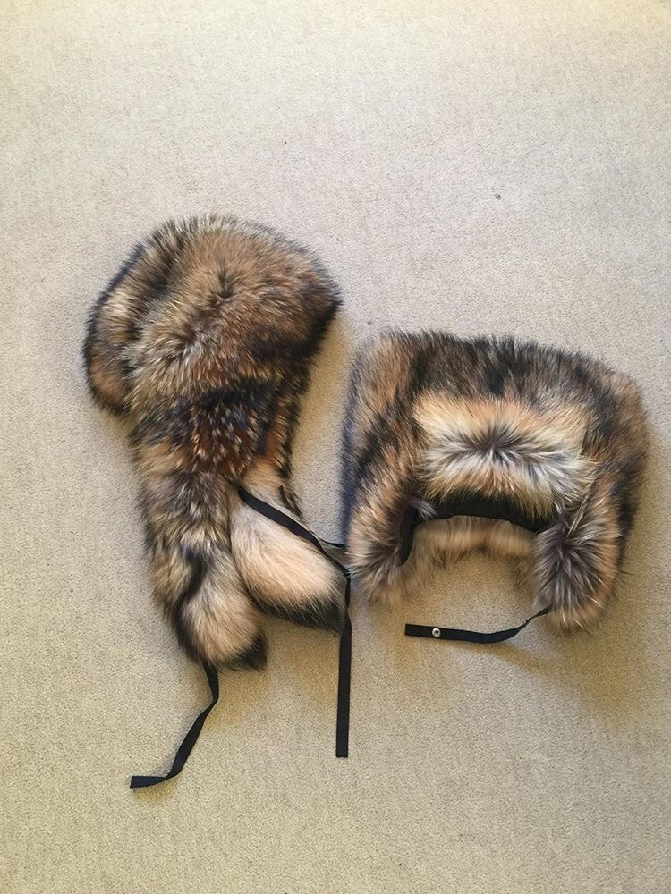 two Russian raccoon fur hats lying on the floor