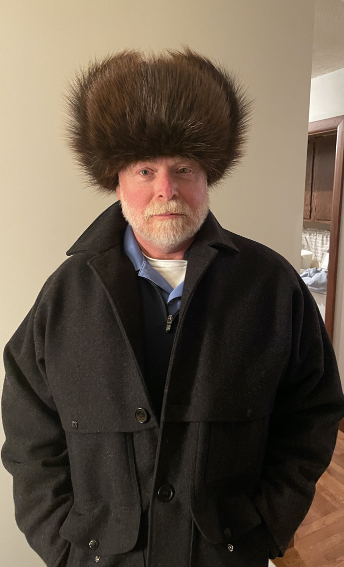 retired military man wearing golden beaver fur ushanka with ears up