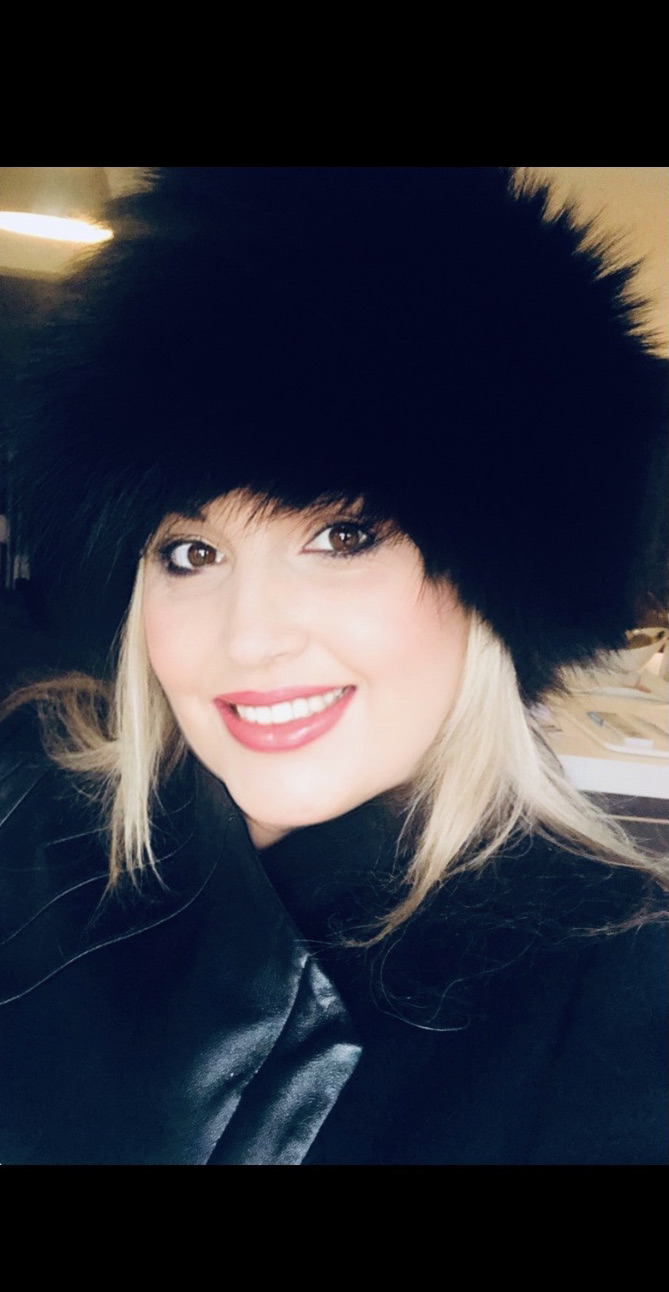 woman wearing full fur Russian boyaryshnia hat with black raccoon fur